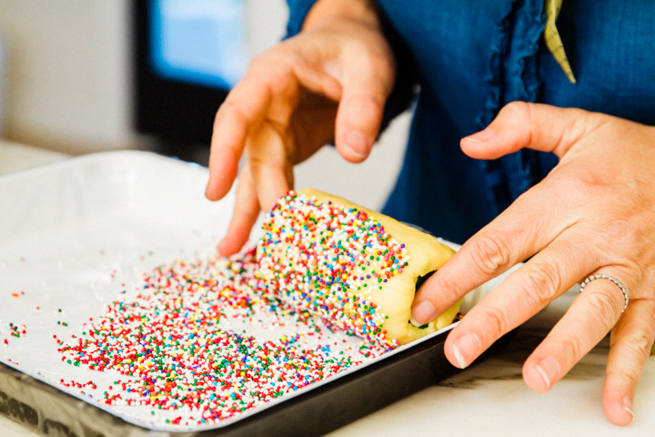 Roll the cylinder of shamrock cookies in rainbow sprinkles